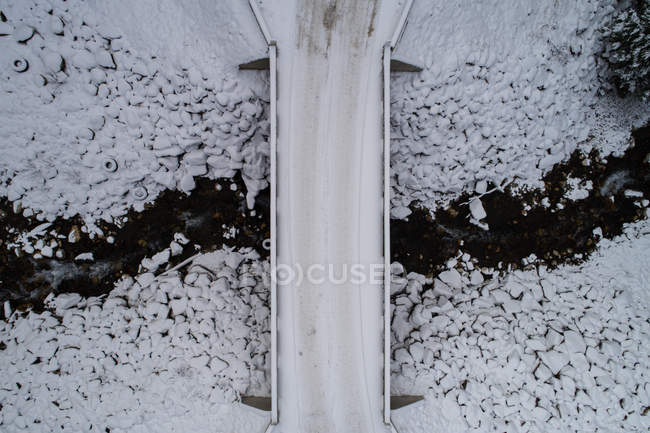 Сніговий покритий міст через потік взимку — стокове фото