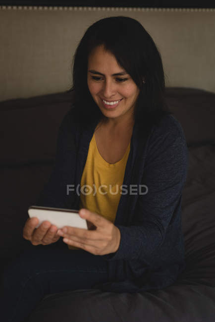 Женщина с видеозвонком на мобильный телефон дома — стоковое фото