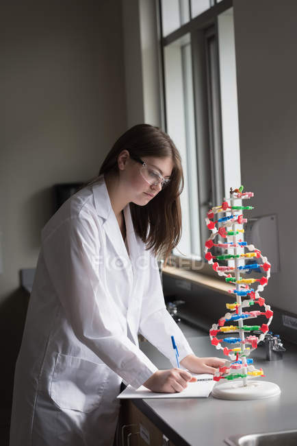 Девочка-подросток экспериментирует с моделью молекул в лаборатории — стоковое фото