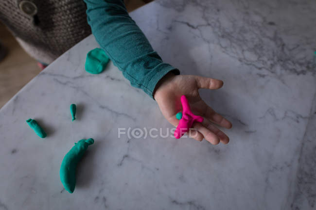 Close-up de menino segurando argila na mão em casa . — Fotografia de Stock