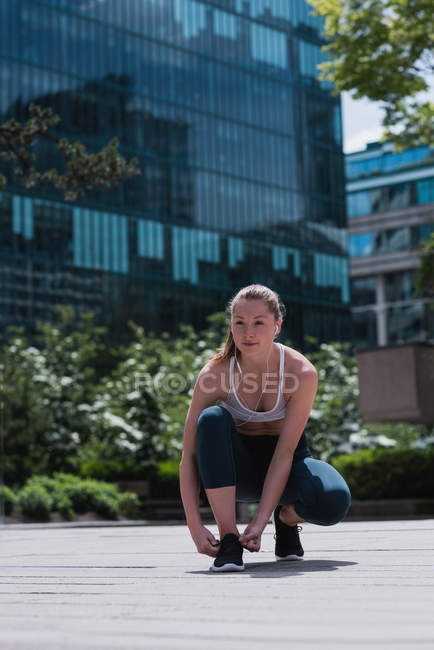 Молода спортивна жінка зав'язує взуття мереживами — стокове фото