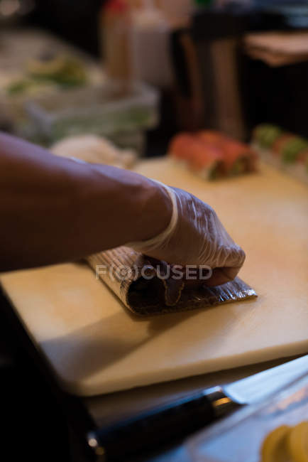Шеф-кухар розгорнуті суші на рубаній дошці — стокове фото