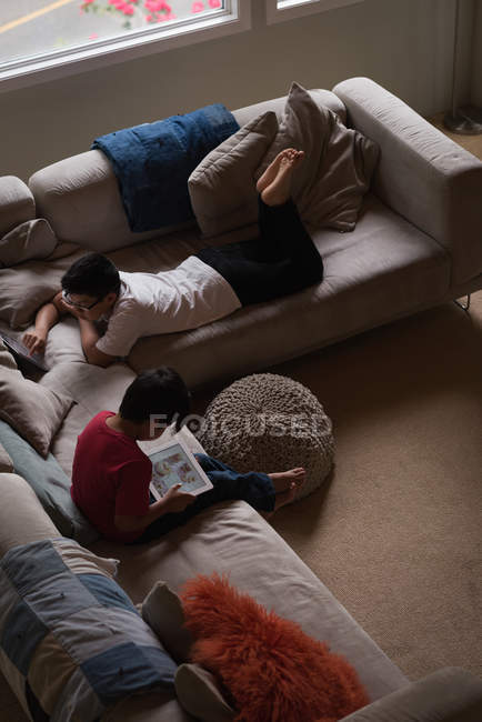 Блудниці використовують цифровий планшет у вітальні вдома — стокове фото