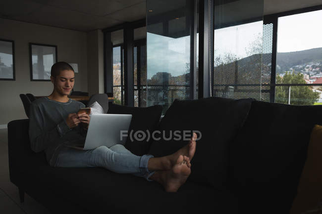 Junger Mann benutzt Handy zu Hause — Stockfoto