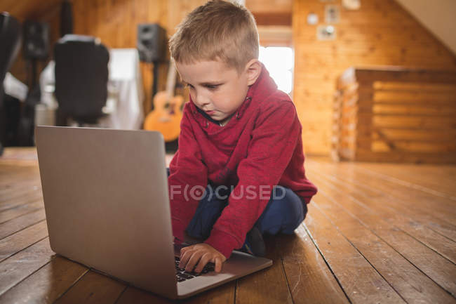Симпатична дитина використовує ноутбук на підлозі вдома — стокове фото