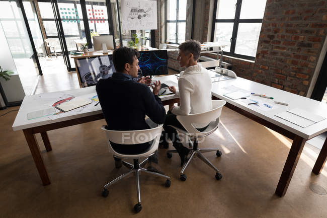 Geschäftskollegen interagieren am Schreibtisch im Büro miteinander. — Stockfoto