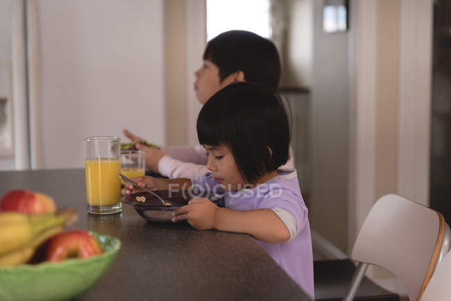 Брат и сестра завтракают за столом на кухне — стоковое фото