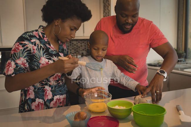 Familie mit Sohn bereitet zu Hause in der Küche Essen zu. — Stockfoto