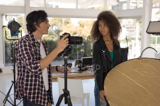 Fotografo maschio che interagisce con la modella in studio — Foto stock