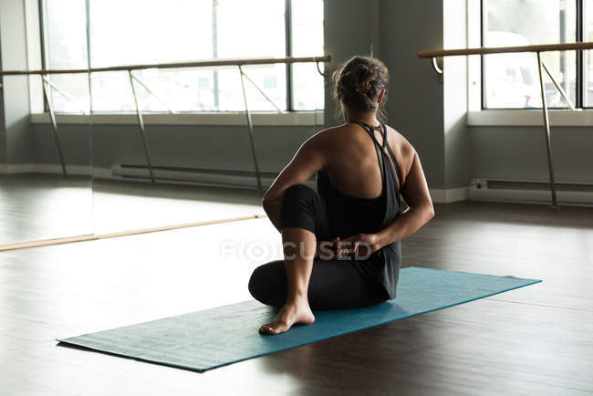 Женщина практикует упражнения на растяжку в фитнес-студии . — стоковое фото