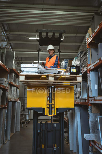 Жіночий працівник перевіряє машину частина на заводі — стокове фото