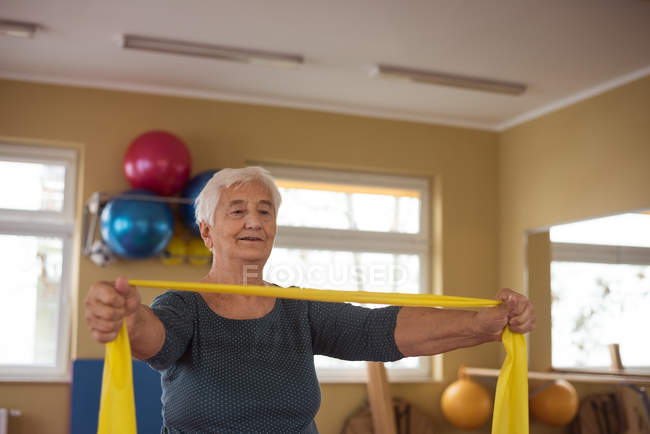 Donna anziana che esegue esercizio con fascia di esercizio — Foto stock