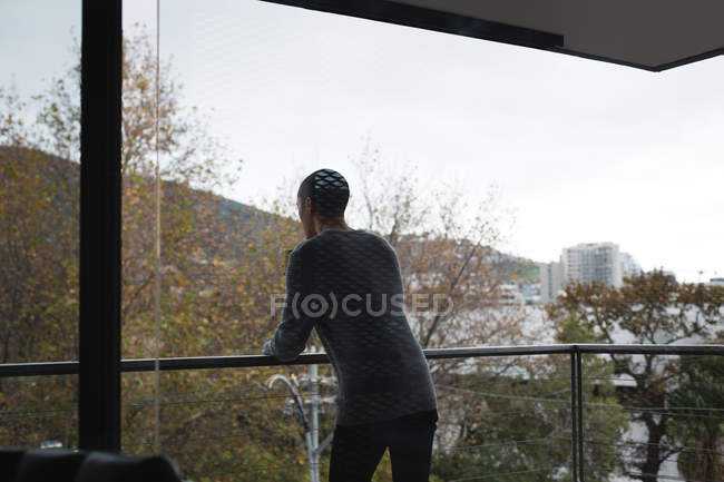 Молодой человек стоит дома на балконе — стоковое фото
