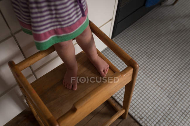 Unterteil eines Kleinkindes, das zu Hause auf einem Hocker steht. — Stockfoto