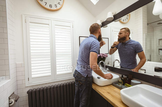 Man standing in front of mirror checking himself in bathroom — Stock Photo