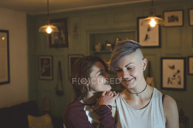 Happy young woman leaning on girlfriend shoulder at home. — Stock Photo