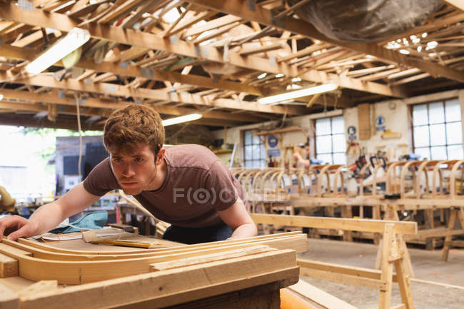 Jeune menuisier travaillant en atelier — Photo de stock