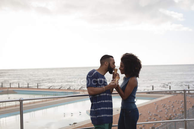 Casal tendo sorvete perto da praia em um dia ensolarado — Fotografia de Stock