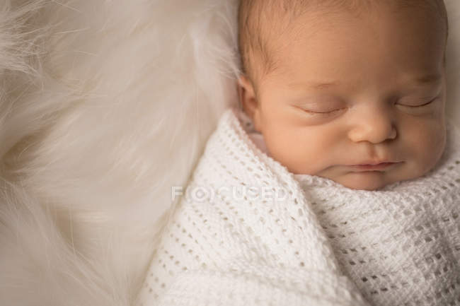 Swaddled newborn baby sleeping on fluffy blanket. — Stock Photo