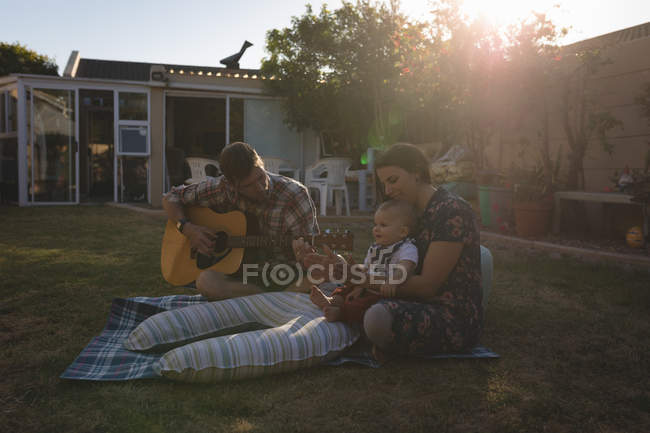 Famille s'amuser dans le jardin pendant le coucher du soleil — Photo de stock