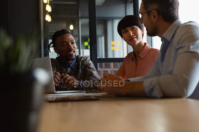 Geschäftskollegen diskutieren im Besprechungsraum im Büro miteinander. — Stockfoto