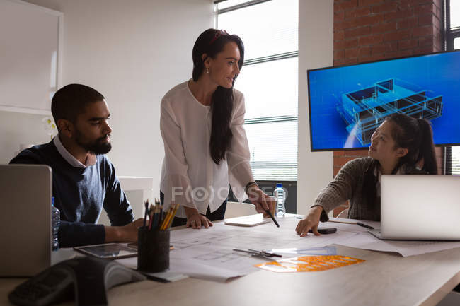 Business colleagues discussing over blueprint in office — Stock Photo