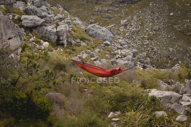 Hiker relaxing in hammock on a sunny day — Stock Photo