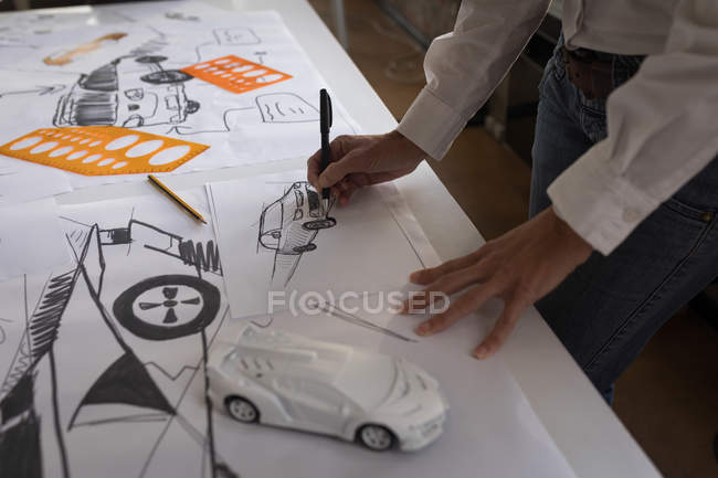 Mid section of businesswoman drawing car sketch in office. — Stock Photo