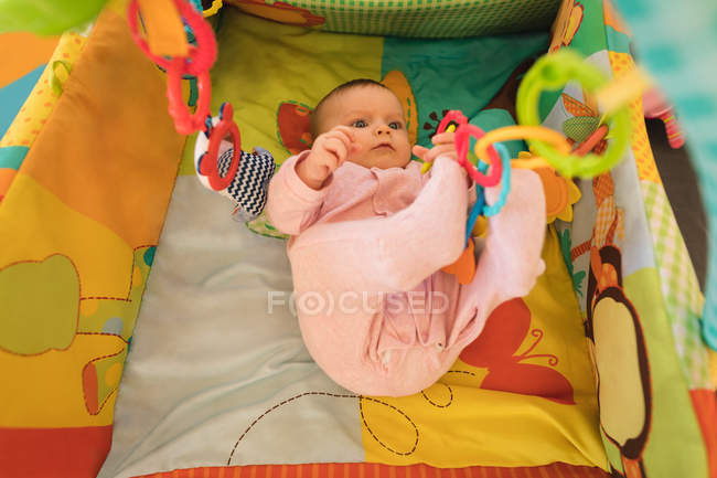 Baby boy relaxing on baby bed at home. — Stock Photo