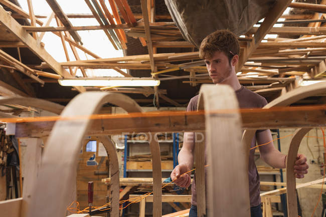 Joven carpintero masculino trabajando en taller - foto de stock