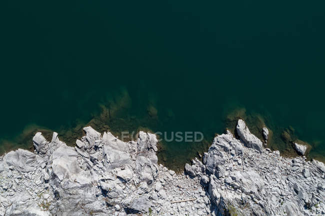 Vista aérea da costa rochosa ao longo do mar azul-turquesa — Fotografia de Stock