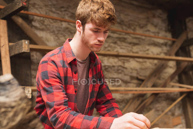 Young male carpenter working in workshop — Stock Photo