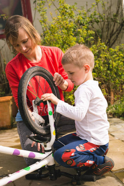 Mutter und Sohn reparieren gemeinsam Fahrrad im Hinterhof — Stockfoto