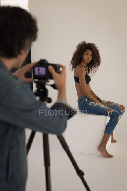 Fotógrafo profesional tomando foto de modelo en estudio - foto de stock