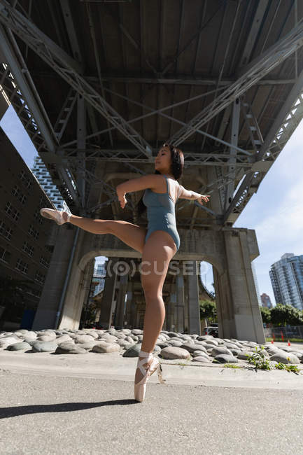 Junge städtische Tänzerin tanzt unter Brücke. — Stockfoto