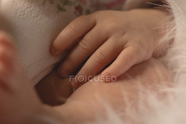 Крупный план руки новорожденного ребенка, лежащего в постели . — стоковое фото
