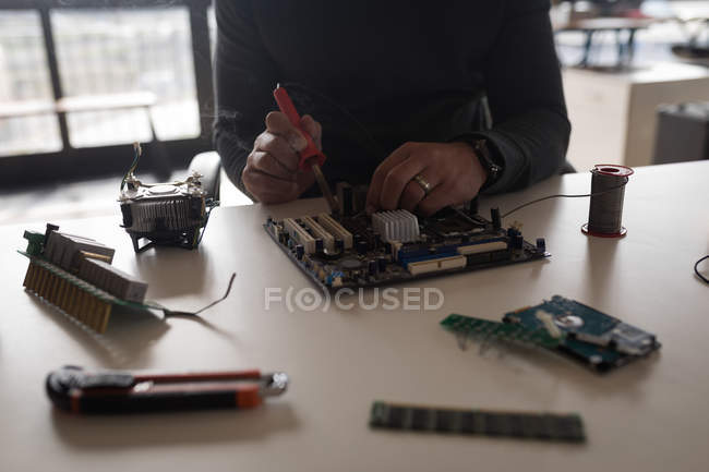 Mid section of male electrical engineer soldering circuit board. — Stock Photo