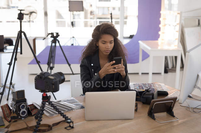 Красивий фотограф використовує ноутбук за столом у фотостудії — стокове фото
