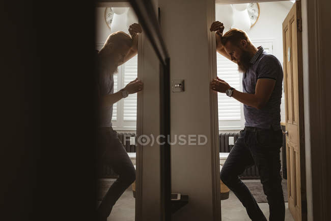 Deprimido homem forro na parede em casa — Fotografia de Stock