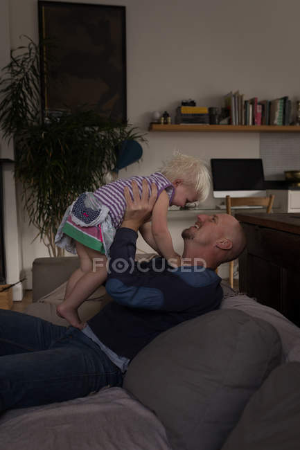 Father playing with daughter in living room at home. — Stock Photo
