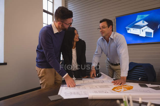 Geschäftskollegen diskutieren im Besprechungsraum im Büro über Baupläne. — Stockfoto