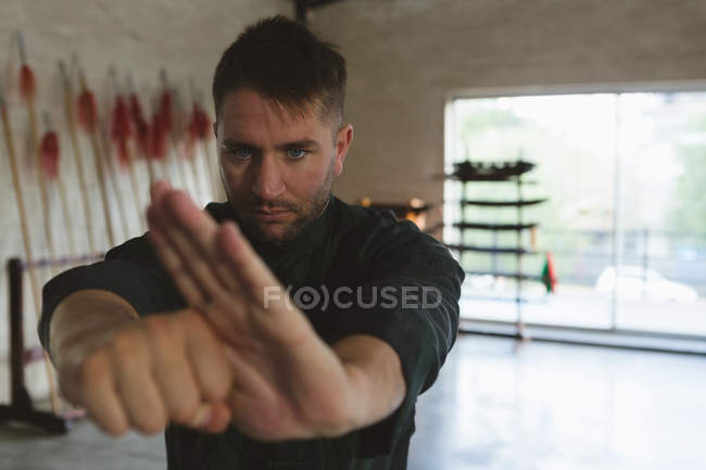 Боец карате практикующий боевые искусства в фитнес-студии . — стоковое фото