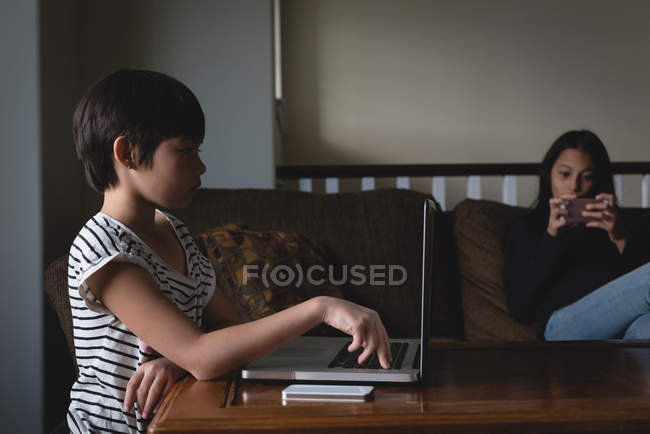 Мальчик использует ноутбук в гостиной дома — стоковое фото