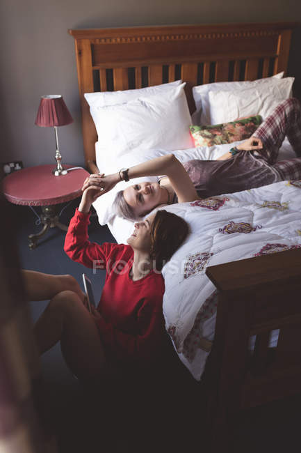 Лесбиянки держатся за руки в спальне дома . — стоковое фото