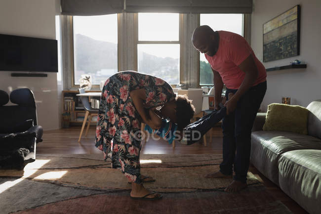Los padres se divierten y llevan a su hijo en la sala de estar en casa . - foto de stock
