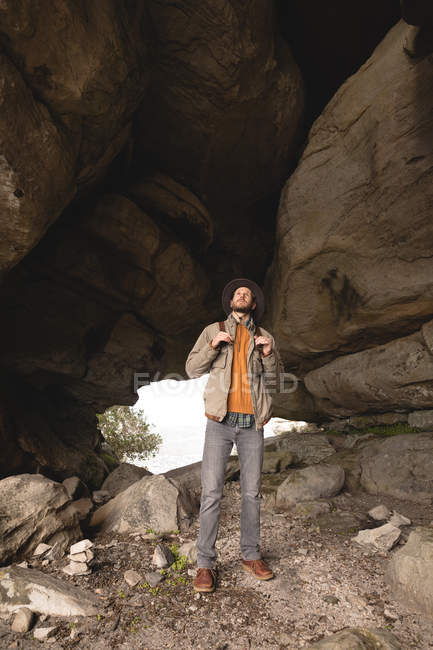 Hiker standing inside the cave on a sunny day — Stock Photo