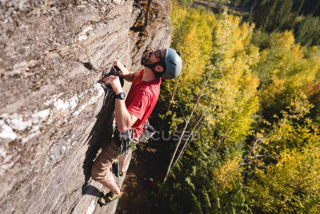 Entschlossener Bergsteiger erklimmt den felsigen Berg — Stockfoto