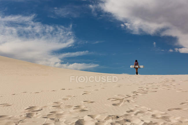 Vista posteriore della donna con lavagna in piedi nel deserto in una giornata di sole — Foto stock