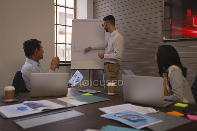 Empresario dando presentación en pizarra en sala de conferencias en la oficina
. - foto de stock
