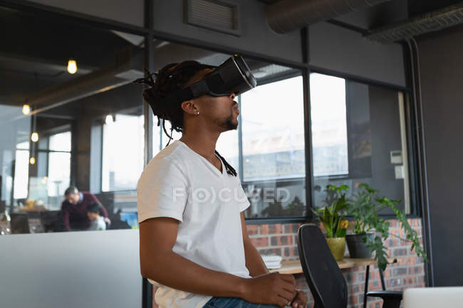 Uomo che sperimenta la realtà virtuale auricolare in ufficio . — Foto stock